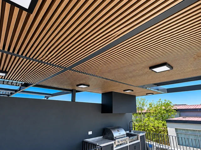 Quincho y terraza: Cobertizo de listones con iluminación integrada.